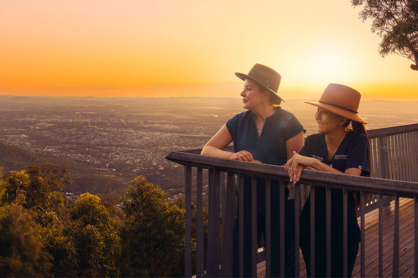 Two doctor looking over rural area from a lookout area at sunset.
