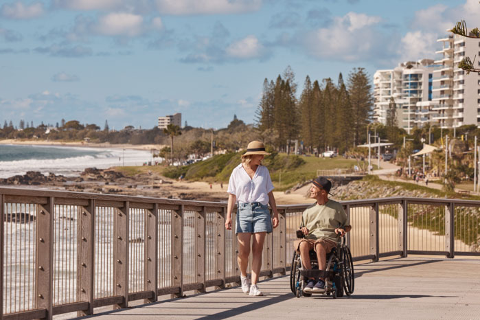 Two people walking along Mooloolaba foreshore boardwalk