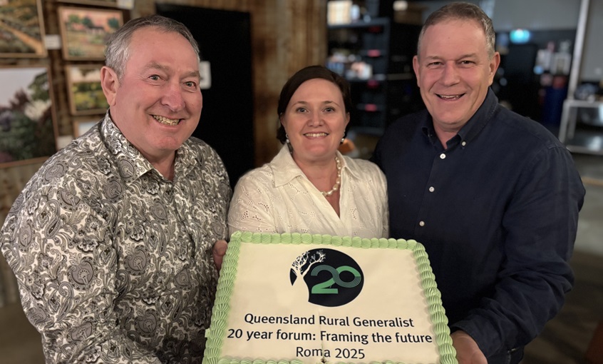 3 doctors smiling, holding a cake that says 'Queensland Rural Generalist 20 year forum: framing the future, Roma 2025'