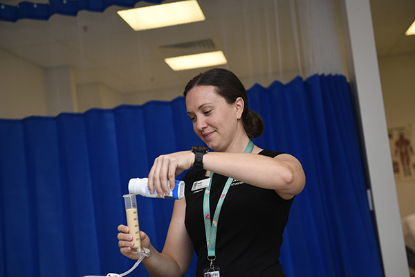 A dietitian, preparing a liquid meal for a patient.