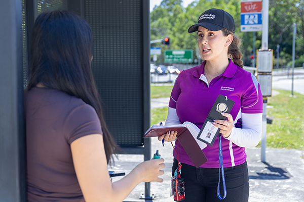 A woman in a purple shirt engages in conversation with another woman.